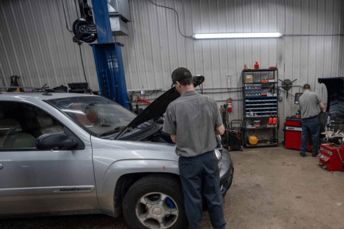 Preventative Maintenance service at Lonsdale Auto Works in Lonsdale, MN. Image of a gray Chevrolet Trailblazer with its hood open, as a mechanic performs preventative maintenance.